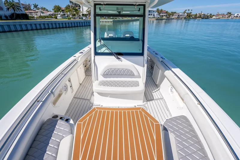 Slide: The Image of 2013 Boston Whaler 320 Outrage boat interior with seating and deck, docked in calm waters. - 22
