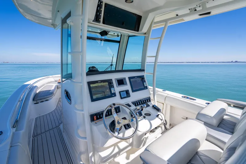 Slide: The Image of 2013 Boston Whaler 320 Outrage boat interior with modern navigation controls on calm sea. - 23