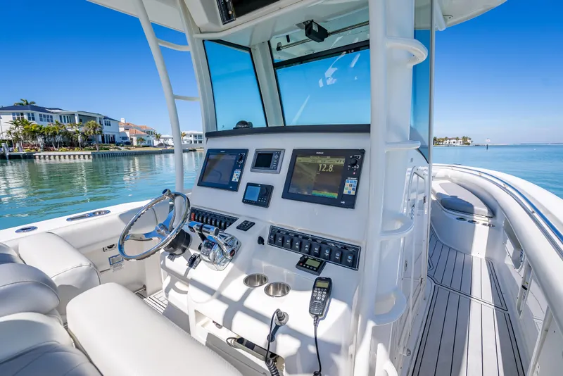 Slide: The Image of 2013 Boston Whaler 320 Outrage boat interior with modern navigation equipment and waterfront view. - 26