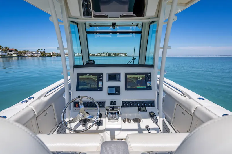 Slide: The Image of 2013 Boston Whaler 320 Outrage boat cockpit with modern navigation equipment on calm water. - 29