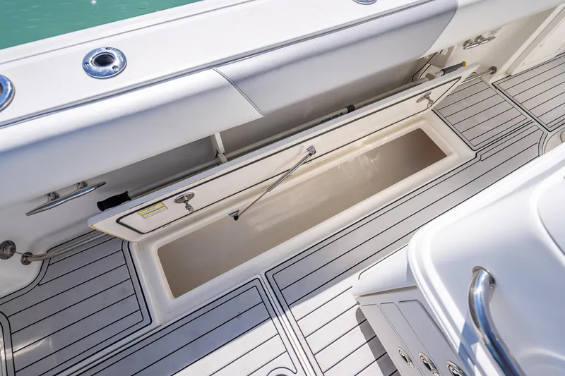 Slide: The Image of 2013 Boston Whaler 320 Outrage boat storage compartment with open hatch, showcasing sleek design. - 33