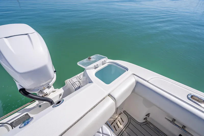 Slide: The Image of 2013 Boston Whaler 320 Outrage boat with motor and open storage compartment on calm water. - 36