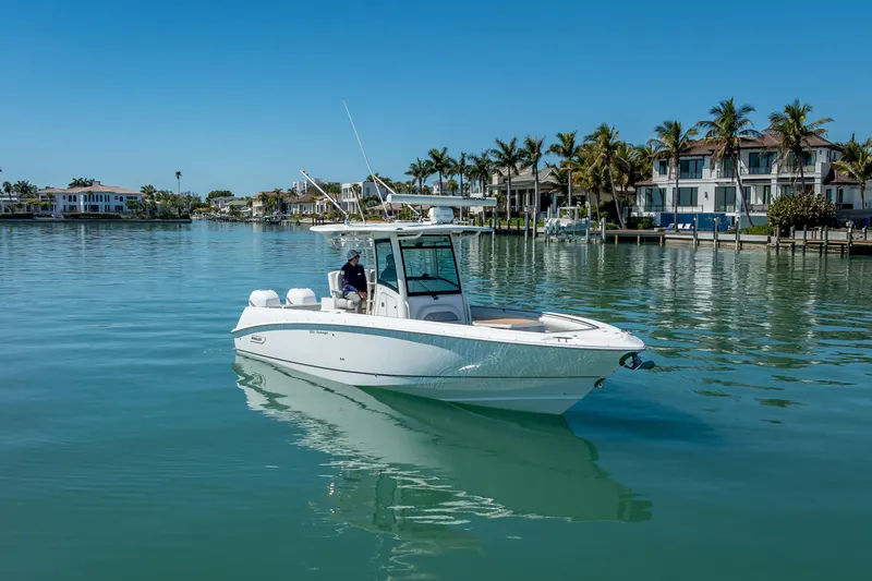 Slide: The Image of 2013 Boston Whaler 320 Outrage boat on calm water near luxury waterfront homes. - 4