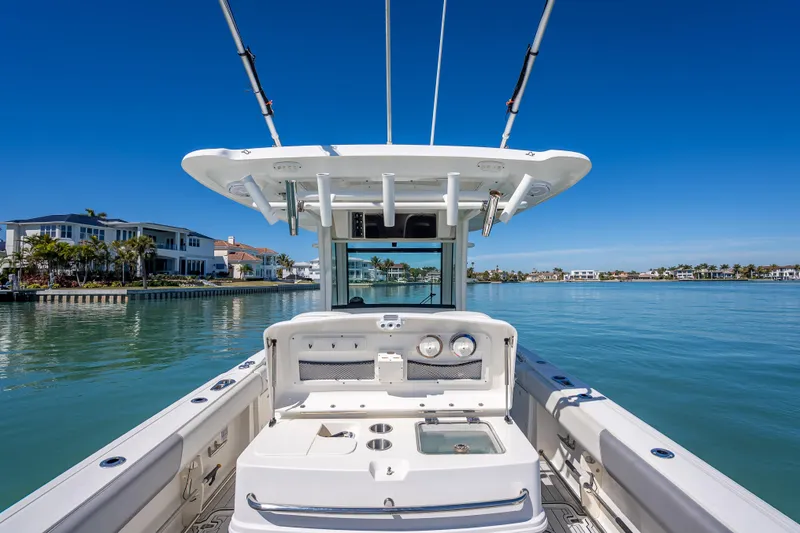 Slide: The Image of 2013 Boston Whaler 320 Outrage boat on calm water, luxury waterfront homes in background. - 41