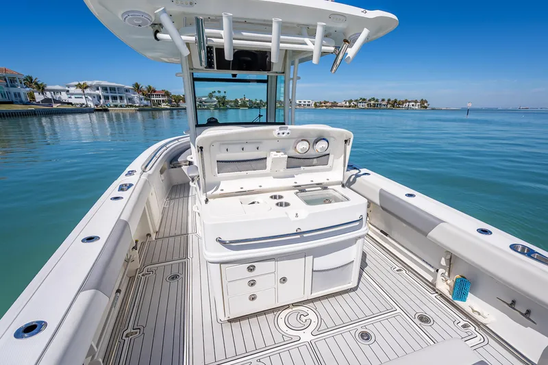 Slide: The Image of 2013 Boston Whaler 320 Outrage boat on calm water, featuring spacious deck and fishing amenities. - 42