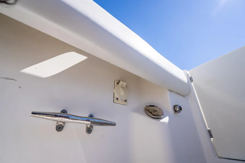 Slide: The Image of 2013 Boston Whaler 320 Outrage boat interior detail with cleat and fittings under clear blue sky. - 45