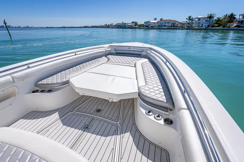 Slide: The Image of 2013 Boston Whaler 320 Outrage boat interior with cushioned seating and ocean view. - 48