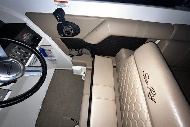 Slide: The Image of 2018 Sea Ray 270 Sundeck interior with beige seating and steering wheel. - 11