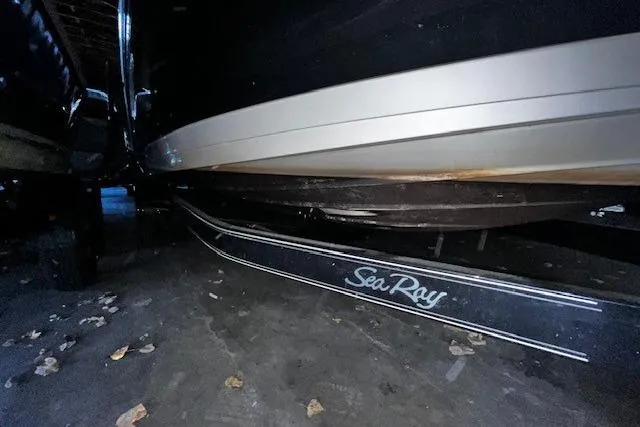 Slide: The Image of 2018 Sea Ray 270 Sundeck boat on trailer, underside view in dimly lit garage. - 22