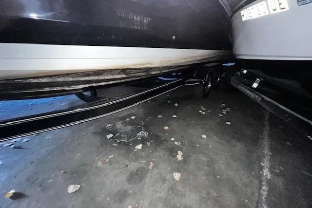 Slide: The Image of 2018 Sea Ray 270 Sundeck on trailer, parked indoors, showing hull and trailer details. - 24