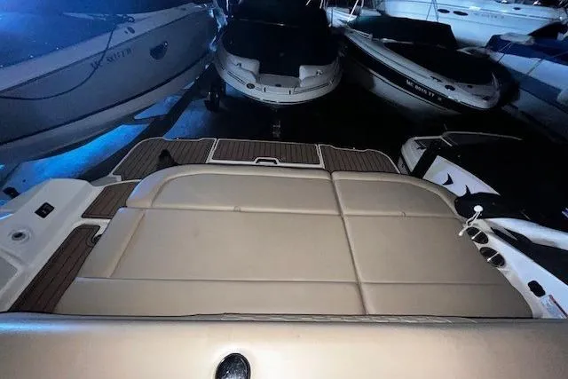 Slide: The Image of 2018 Sea Ray 270 Sundeck boat interior with cushioned seating and wood accents. - 7