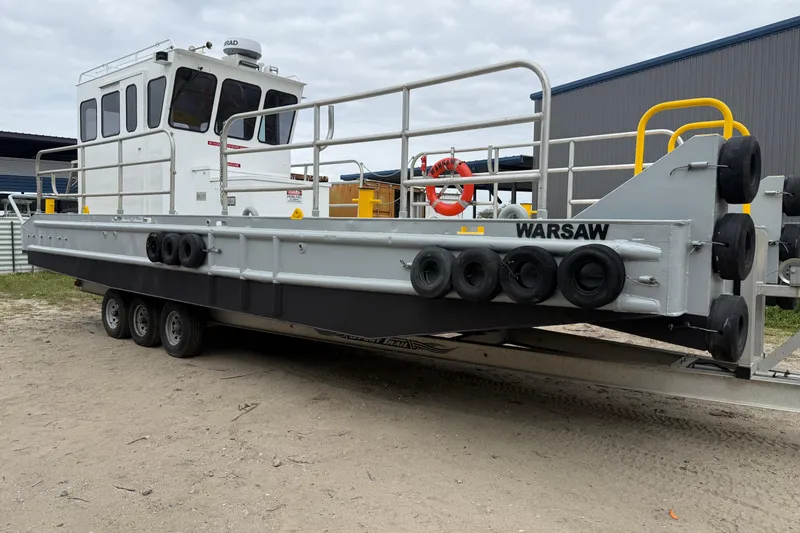 Slide: The Image of Custom Aluminum Work Boat 34x10, 2010 model, on trailer with safety railings and fenders. - 1