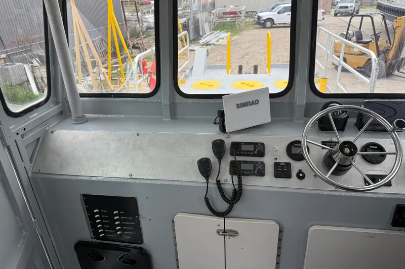 Slide: The Image of Pilothouse interior of 2010 Custom Aluminum Work Boat, featuring steering wheel and navigation equipment. - 10