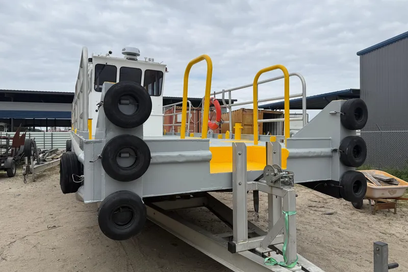 Slide: The Image of Custom Aluminum Work Boat 34x10, 2010 model, docked with safety railings and tires. - 2