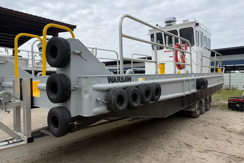 Slide: The Image of Custom Aluminum Work Boat 34x10, 2010 model, docked with safety railings and tires. - 3