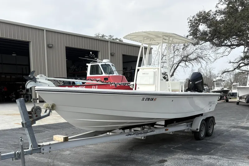 Slide: The Image of 2022 Pathfinder 2400 TRS boat on trailer, parked outside a warehouse. - 6
