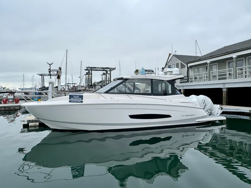 Slide: The Image of 2026 Regal 36 XO yacht docked at marina, overcast sky, calm water reflection. - 12