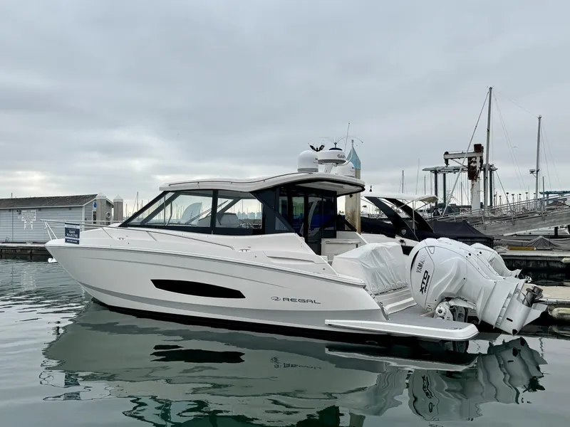 Slide: The Image of 2026 Regal 36 XO boat docked at marina, featuring sleek design and twin outboard engines. - 13
