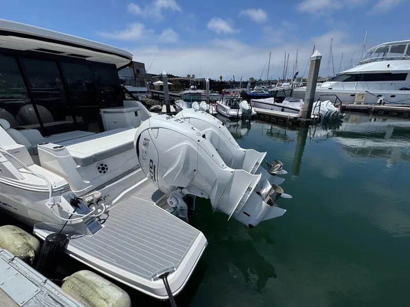 Slide: The Image of 2026 Regal 36 XO boat docked with dual outboard engines in a marina. - 15