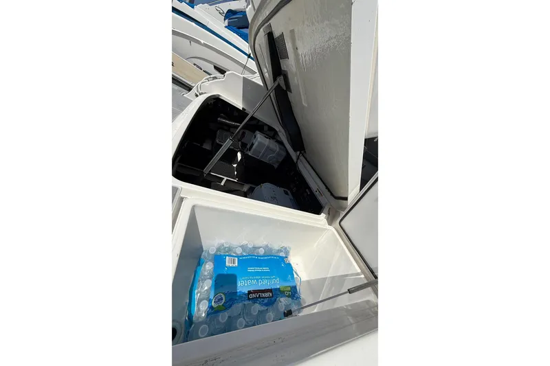 Slide: The Image of Open storage compartment on 2026 Regal 36 XO boat with bottled water inside. - 18