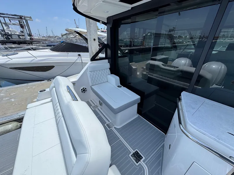 Slide: The Image of 2026 Regal 36 XO yacht interior with sleek seating and modern design at a marina. - 25