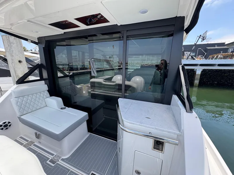 Slide: The Image of 2026 Regal 36 XO yacht interior with seating and sliding glass doors. - 26