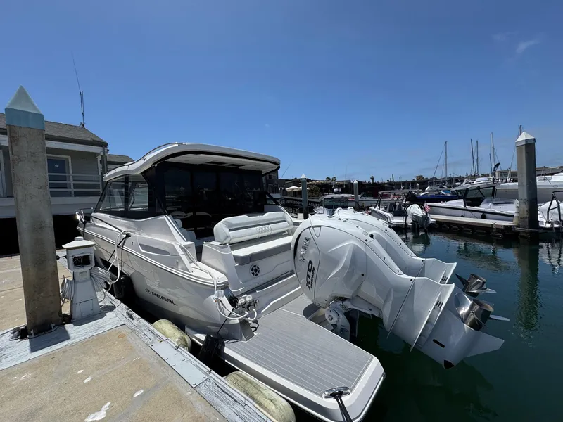 Slide: The Image of 2026 Regal 36 XO boat docked at marina with twin outboard engines. - 27