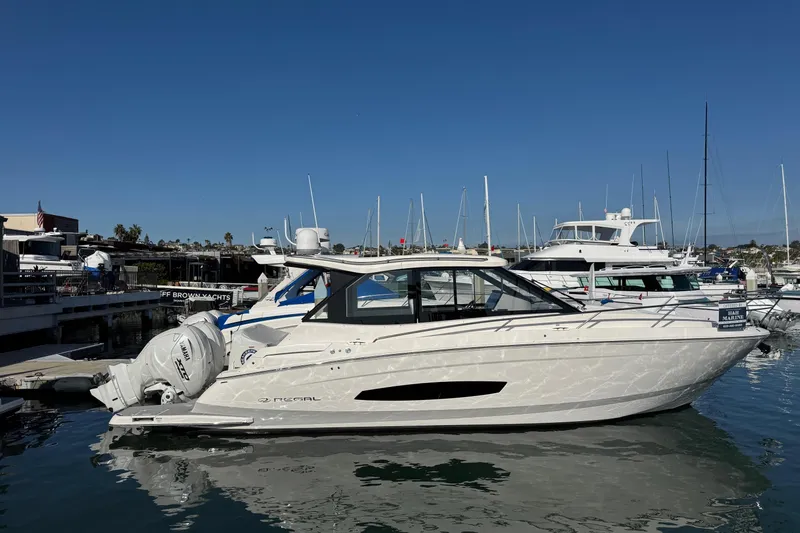 Slide: The Image of 2026 Regal 36 XO yacht docked at marina under clear blue sky. - 3