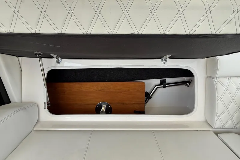 Slide: The Image of 2026 Regal 36 XO boat interior storage compartment with white cushioned seating. - 45