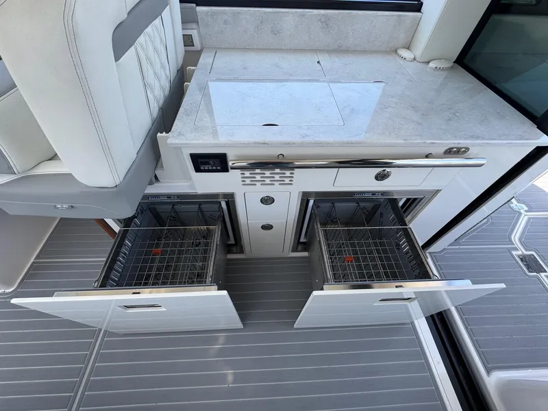 Slide: The Image of 2026 Regal 36 XO yacht kitchen with open dual-drawer dishwashers and sleek countertop. - 53