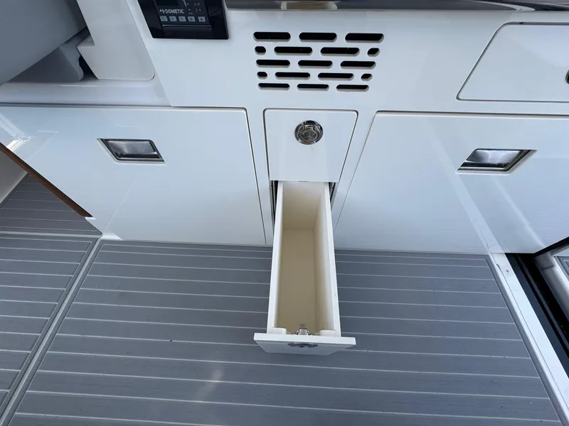 Slide: The Image of 2026 Regal 36 XO boat interior with open storage drawer on sleek flooring. - 55