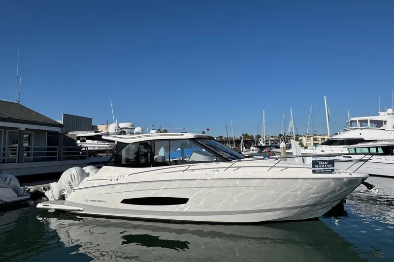 Slide: The Image of 2026 Regal 36 XO luxury yacht docked at marina under clear blue sky. - 6