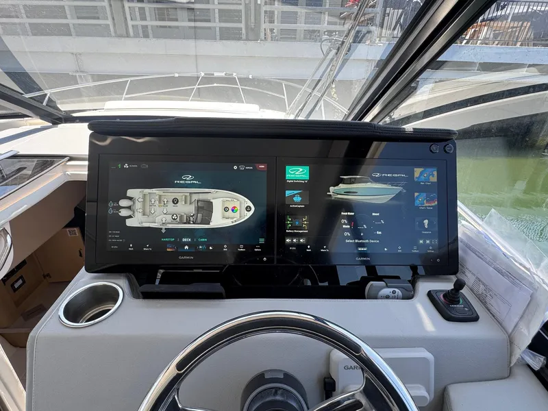 Slide: The Image of Helm of 2026 Regal 36 XO boat with dual touchscreen displays and steering wheel. - 60