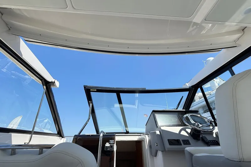 Slide: The Image of Interior view of 2026 Regal 36 XO yacht cockpit with steering wheel and clear sky. - 68