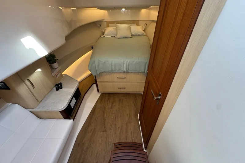 Slide: The Image of Interior of 2026 Regal 36 XO yacht cabin with bed, seating, and wood flooring. - 76