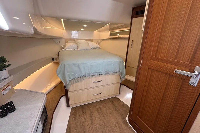 Slide: The Image of Luxurious cabin interior of 2026 Regal 36 XO yacht with cozy bed and wooden accents. - 77