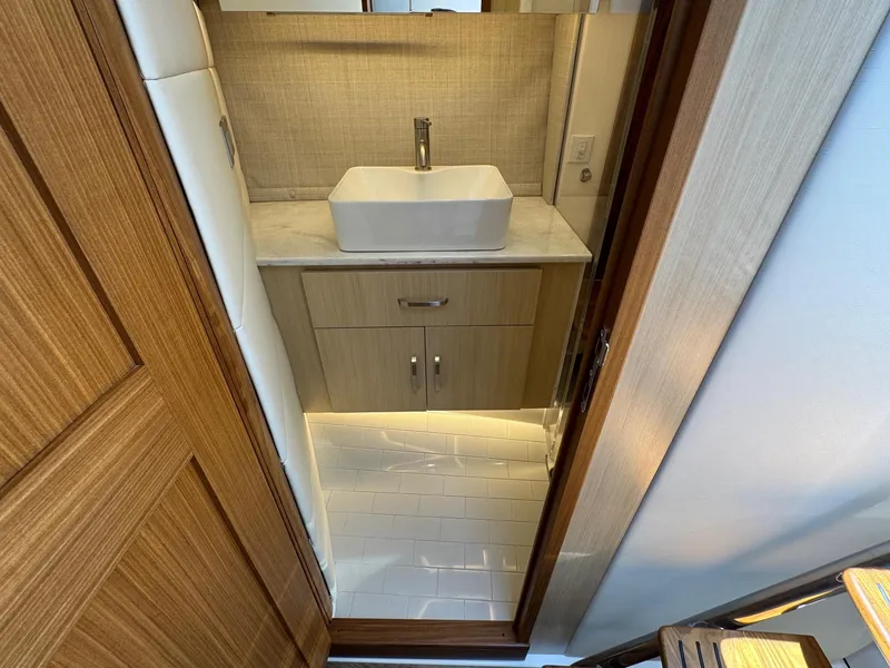 Slide: The Image of Modern bathroom interior on 2026 Regal 36 XO yacht, featuring sleek sink and wooden cabinetry. - 78