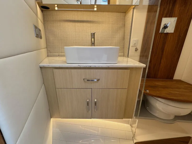 Slide: The Image of Modern bathroom interior of 2026 Regal 36 XO yacht, featuring sleek sink and wooden cabinetry. - 79