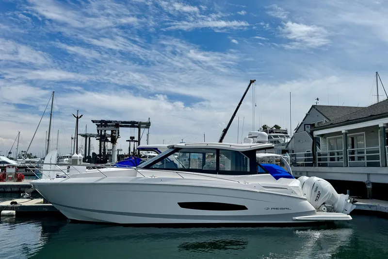 Slide: The Image of 2026 Regal 36 XO yacht docked at marina under blue sky. - 9