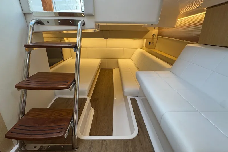 Slide: The Image of Luxurious interior of 2026 Regal 36 XO yacht with white seating and wooden steps. - 94