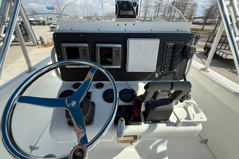 Slide: The Image of 2004 Glacier Bay 260 Canyon Runner boat dashboard with steering wheel and navigation controls. - 14