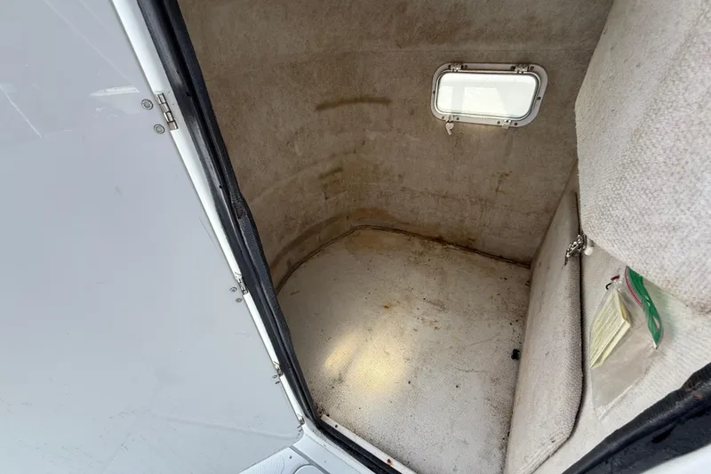 Slide: The Image of 2004 Glacier Bay 260 Canyon Runner cabin interior with small window and storage space. - 15