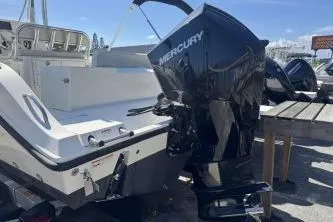 Slide: The Image of 2022 Cobia 237 Center Console boat with Mercury outboard motor, docked under clear skies. - 15