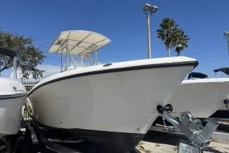 Slide: The Image of 2022 Cobia 237 Center Console boat on trailer under clear blue sky. - 2