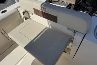 Slide: The Image of 2022 Cobia 237 Center Console boat seat, beige upholstery, foldable design. - 7