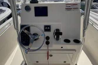Slide: The Image of 2022 Cobia 237 Center Console boat dashboard with steering wheel and controls. - 8