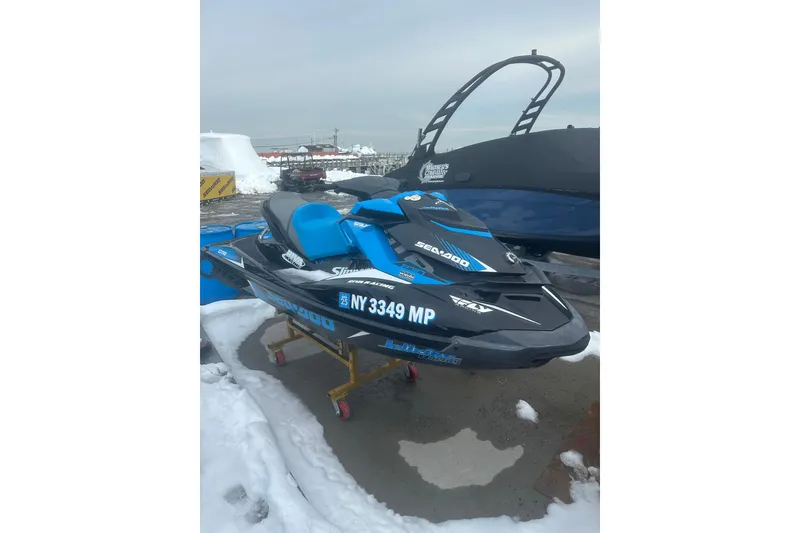 Slide: The Image of 2019 Sea-Doo GTR 230 jet ski on snowy dock, blue and black design. - 2