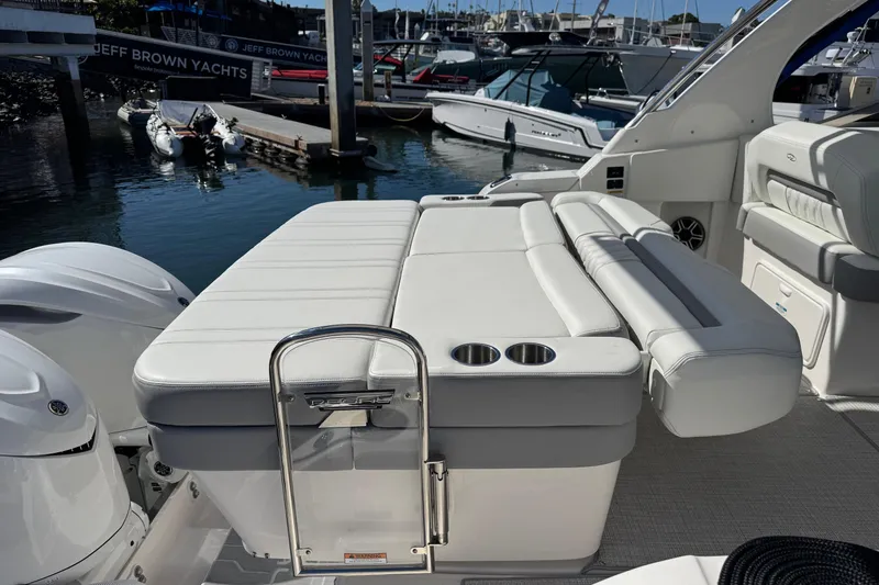 Slide: The Image of 2026 Regal 33 XO yacht with luxurious seating and cup holders at a marina. - 19