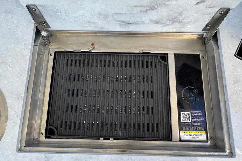 Slide: The Image of Built-in Kenyon grill on Regal 33 XO 2026 boat, featuring sleek stainless steel design. - 33