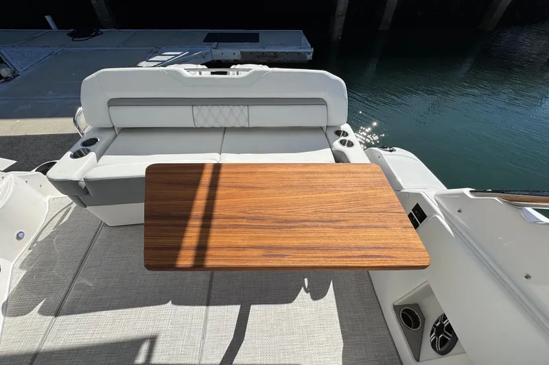 Slide: The Image of 2026 Regal 33 XO boat interior with wooden table and cushioned seating. - 43